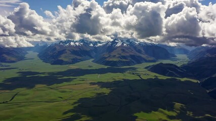 Wall Mural - Majestic mountain range under dramatic clouds casting shadows, scenic aerial view. Nature adventure and exploration concept