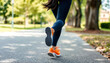 © shehroz khan - A Determined Runners Vibrant Orange Shoes Pounding The Pavement, A Blur Of Motion Against A Sun-dappled Park Path, Showcasing Energy And Fitness