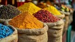 © SerPak - Colorful spices on display in burlap sacks at a vibrant market stall.