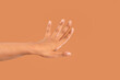 © Iryna - Elegant hand gesture against a warm, neutral background creating a serene visual expression of openness and communication