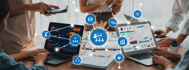 Fototapete - Teams collaborate in a modern workspace, analyzing data on laptops and discussing insights through infographics and digital tools, highlighting innovative teamwork. Amity