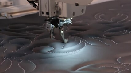 Poster - Sewing machine is in use on a black fabric. The machine is making a pattern on the fabric
