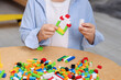 © New Africa - Cute boy playing with building blocks at wooden table indoors, closeup