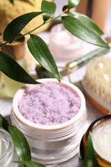 Wall Mural - different body care products and branches with leaves on light table, closeup