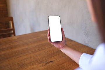 Wall Mural - mockup image of a woman holding black mobile phone with blank desktop screen