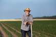 © Budimir Jevtic - Senior farmer leaning on hoe in field in summer