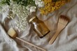 © Khatyjay - Glass jar surrounded by natural flowers and wooden brushes on a soft fabric background