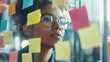 © zeitgenstd - Focused Woman Brainstorming with Sticky Notes