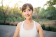 © Jirawatfoto - Asian woman outdoor workout. Healthy and active lifestyle concept. She smiles confidently in serene park setting, embracing fitness and nature