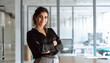 © Stock 4 You - Portrait of successful middle eastern young business woman with crossed arms smiling confident at camera. Latina or indian female manager leader specialist businesswoman standing in office. Copy space