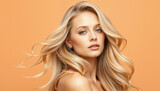 Close-up portrait of a stunning woman, featuring wavy blonde hair, blue eyes, and an orange background, highlighting beauty and simplicity.

