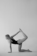 © Vazgen Waka - young beautiful athletic woman doing yoga on studio background, wearing black bodysuit