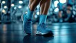 © Tania - Blue athletic shoes on gym floor with exercising individuals in background