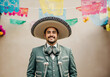 Portrait of a mariachi musician smiling, wearing a traditional charro suit and sombrero, with colorful papel picado flags in the background