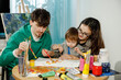 © ces - Young family with their son painting and having fun in the room