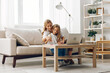 © SHOTPRIME STUDIO - Mother and daughter bonding on a cozy couch, sharing a laptop screen and enjoying quality time together