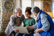 © NDABCREATIVITY - Portrait of a happy multigeneration family using electronic devices at home together