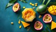 ©  VladaToday - Hyper realistic top view of fresh tropical fruits mango and passionfruit on teal background with copy space