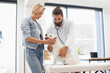 © sofiko14 - Man veterinarian examining small dog using stethoscope with blonde woman nearby in clinic setting