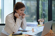 © Jirapong - Confident business woman smiling Show successful gestures at her desk with market charts and documents in office