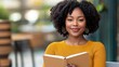 © medalinebow - Young woman with curly hair enjoying a book in a cozy outdoor cafe setting