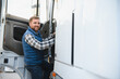 © Serhii - Truck driver climbing into cab of semi truck