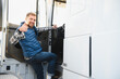 © Serhii - Truck driver climbing into cab of semi truck
