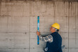© Ljustina - Construction worker using spirit level on concrete wall