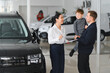 © Serhii - Father and son choosing a new car to buy at the car showroom
