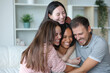 © PheelingsMedia - Happy group of best interracial friends hugging at home