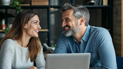 Poster - In a modern office, two professionals have a productive discussion over a laptop, highlighting the importance of teamwork and innovation in todays evolving business technology landscape