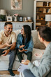 © La Famiglia - Young couple discussing with their psychologist during therapy session