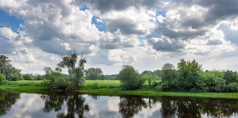 Wall Mural - a cloudy sky with a lake in the foreground