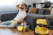 © standret - Tired, sitting on the floor and taking a break. Male professional cleaning service worker is domestic room