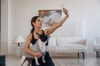 © standret - Making selfie. Sportive woman in yoga clothes is with pug dog at home