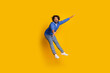 © deagreez - Cheerful young male jumping and gesturing dynamically against a vibrant yellow background showcasing joy