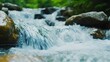 © Wannapha - Gentle stream flowing over smooth rocks, serene nature scene, vibrant greenery surrounding water, perfect for tranquil themes.