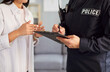 © Studio Romantic - Close-up of a male police officer or detective writing a report at a crime scene. Dedication of law enforcement to investigate crime, ensuring public safety and thorough documentation.