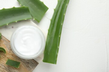 Wall Mural - cream and aloe leaves on white textured background, flat lay. space for text
