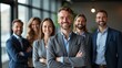 © julfiar - Portrait of successful group of business people at modern office looking at camera. Portrait of happy businessmen and satisfied businesswomen standing as a team. Multiethnic group of people smiling.