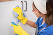 © Kawee - Asian young beautiful female cleaner worker cleaning kitchen at home.