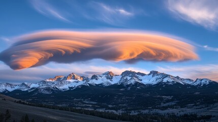 Wall Mural - Lenticular cloud over snow-capped mountains at sunset, scenic landscape view