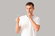 © Pixel-Shot - Thoughtful young man with cotton buds on grey background