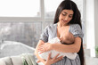 © Pixel-Shot - Woman breastfeeding her baby at home