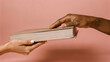 © Татьяна Микитченко - Exchange of a book between two hands against a soft pink background
