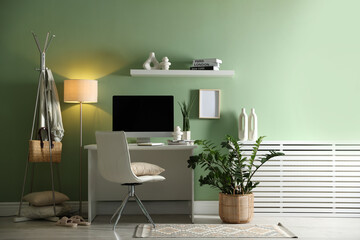 Aufkleber - Home office. Comfortable workplace with desk, computer and lamp near light green wall in room