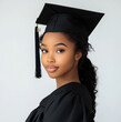 © Eva - photo of beautiful black 18 year old female graduate wearing a black graduation robe and cap on a white background