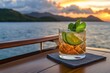 © Thammarong - A tropical sunset as seen from the deck of a cruise ship, with a cocktail in hand