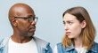 © Postmodern Studio - African male adult and caucasian female young conversing against blue background