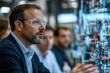 © Milos - A group of engineers are focused on innovative technology solutions displayed on interactive screens, emphasizing the future of engineering and teamwork in problem-solving.